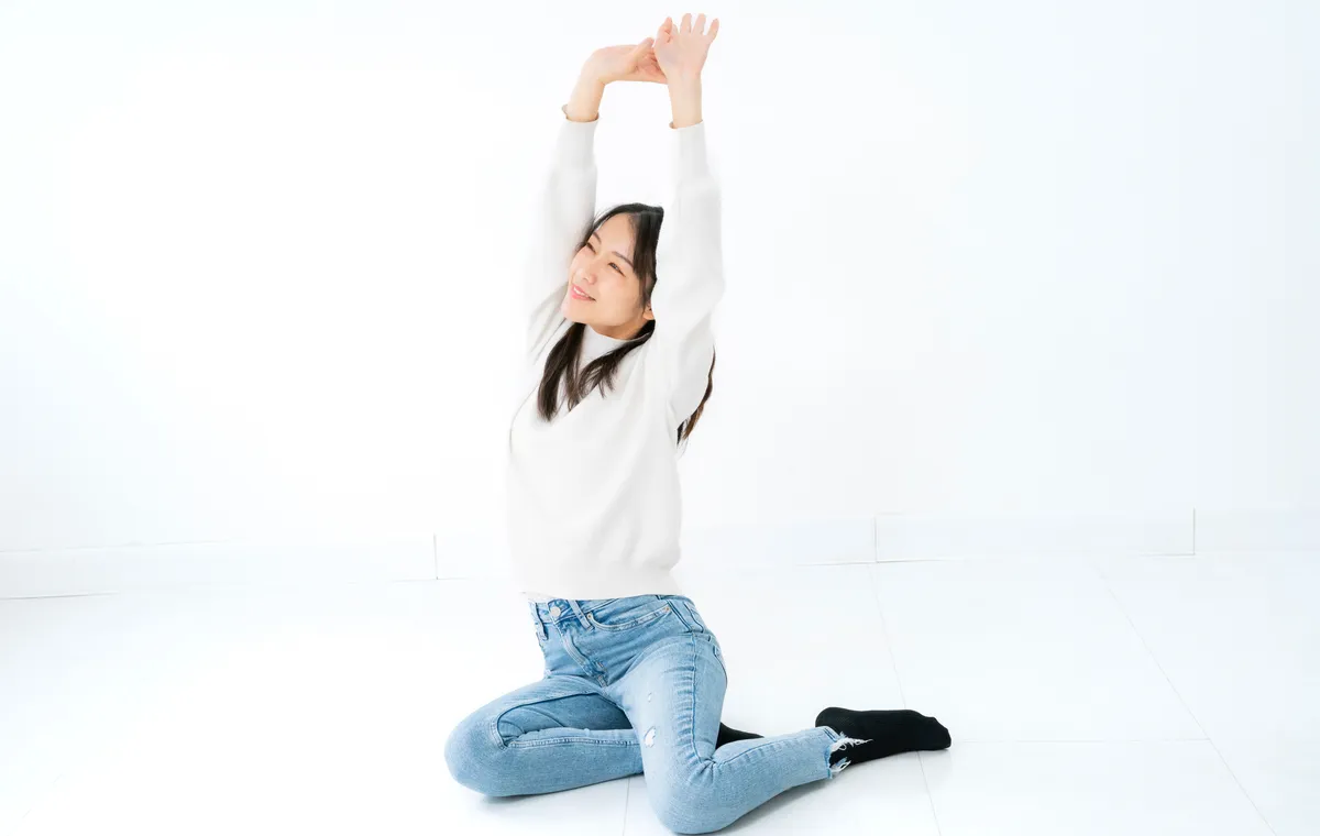自然光の差し込む静かなスタジオでヨガをする女性